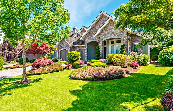 Wonderfully maintained modern stone house with perfectly manicured curb appeal and healthy lawn and grass